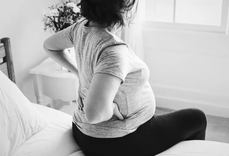 Pregnant woman using comfortable posture to ease back pain during pregnancy